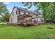 Beautifully landscaped backyard showcasing a spacious lawn, wooden deck, and a charming pergola at 107 Glenmont Ct, Mooresville, NC 28117