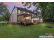 Evening view of the backyard with illuminated deck and pergola, creating a cozy outdoor space at 107 Glenmont Ct, Mooresville, NC 28117