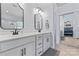 This is a bathroom with double sinks, white cabinets, and a black and white rug, with a mirror reflection of the bedroom at 107 Glenmont Ct, Mooresville, NC 28117