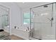 This bathroom is equipped with a glass-enclosed shower and a luxurious soaking tub with a window at 107 Glenmont Ct, Mooresville, NC 28117