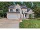 Charming two-story home featuring a well-manicured lawn, two-car garage, and inviting front porch at 107 Glenmont Ct, Mooresville, NC 28117