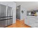 Spacious kitchen featuring white cabinets, stainless steel refrigerator, and hardwood floors at 107 Glenmont Ct, Mooresville, NC 28117