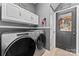 Modern laundry room with gray cabinets, updated appliances, and a back door at 107 Glenmont Ct, Mooresville, NC 28117