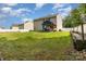 Backyard featuring a spacious green lawn, white fence, and covered patio at 10816 Pointer Ridge Dr, Charlotte, NC 28214