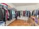 Walk-in closet with wood floors, lots of hanging clothes, shelves, and folded items at 10816 Pointer Ridge Dr, Charlotte, NC 28214