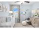 Charming Bedroom with a white crib, soft blue walls, decorative animal prints, and natural light at 11034 Engelmann Ln, Charlotte, NC 28269