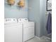 Bright laundry room features a washer and dryer, and a rack for additional storage at 11034 Engelmann Ln, Charlotte, NC 28269