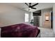 Comfortable bedroom with a ceiling fan, television, chest of drawers and a cozy bed with purple bedding at 1195 Cavalier Ln, Rock Hill, SC 29730