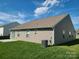 Well-maintained backyard with a concrete patio, lush green grass, and vinyl siding on a sunny day at 1195 Winding Creek Rd, Salisbury, NC 28146