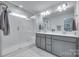 Bright bathroom with double sinks, sleek vanity, and frameless glass shower at 12024 John Newton Dr, Davidson, NC 28036