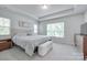 A bright primary bedroom with a tray ceiling, a large window, and neutral decor, providing a serene atmosphere at 12024 John Newton Dr, Davidson, NC 28036