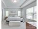Bedroom featuring a tray ceiling, a large window, and neutral carpeting at 12024 John Newton Dr, Davidson, NC 28036