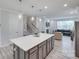 Kitchen island with a white countertop and gray cabinets, opening to the living room with a fireplace and staircase at 12024 John Newton Dr, Davidson, NC 28036