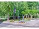 Welcoming neighborhood entrance with lush landscaping, mature trees, and community signage at 12024 John Newton Dr, Davidson, NC 28036