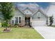 Charming home featuring stone accents, well-manicured lawn, flower beds, and a two-car garage at 132 Hillston Ln, Mooresville, NC 28115