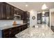 Modern kitchen featuring dark cabinets, granite counters, stainless appliances, and a kitchen island at 132 Hillston Ln, Mooresville, NC 28115
