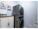 A modern laundry room features stacked washer and dryer and a white cabinet at 132 Hillston Ln, Mooresville, NC 28115