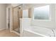 Bright bathroom featuring a tub, shower, and large window at 133 Yellowbell Rd, Mooresville, NC 28117