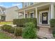 Inviting front porch with classic columns, a black front door, and neat landscaping at 133 Yellowbell Rd, Mooresville, NC 28117