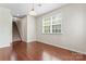 Versatile living space showcasing hardwood floors, a window with natural light, and access to the upper level at 133 Yellowbell Rd, Mooresville, NC 28117