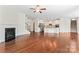 Open-concept living room with hardwood floors, fireplace, and seamless access to the kitchen and staircase at 133 Yellowbell Rd, Mooresville, NC 28117