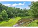 Scenic view of the backyard pond bordered by a black fence and lush greenery at 133 Yellowbell Rd, Mooresville, NC 28117