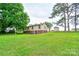 Large backyard with green lawn, mature trees, and view of the back of the house at 1529 Stony Point Rd, Shelby, NC 28150