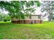 Backyard view of a two-story house with brown and cream colored siding, green lawn, and mature trees at 1529 Stony Point Rd, Shelby, NC 28150