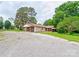 View of the building's exterior featuring a covered side porch and ample parking space, surrounded by lush greenery at 1529 Stony Point Rd, Shelby, NC 28150