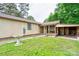 Exterior view of a home's side featuring a covered porch, lush greenery, and a serene birdbath at 1529 Stony Point Rd, Shelby, NC 28150