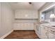 Traditional style kitchen featuring white appliances, backsplash, cabinets, and wood-look laminate flooring at 1529 Stony Point Rd, Shelby, NC 28150