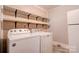 Clean, well-maintained laundry room with a washer and dryer and open shelving for supplies at 1529 Stony Point Rd, Shelby, NC 28150