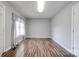 Bright living room with laminate flooring, light gray walls and trim, window, and paneled interior door at 1529 Stony Point Rd, Shelby, NC 28150