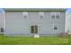 Exterior view of the backyard featuring a grassy lawn, sliding glass door, and light-blue siding at 1543 Cottage Creek Dr, Bessemer City, NC 28016