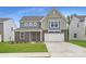 Charming two-story home with a well-manicured lawn, brick accents, and a two-car garage at 1543 Cottage Creek Dr, Bessemer City, NC 28016