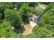 High aerial view of a home with a dark metal roof amid lush trees and a long driveway at 1773 Baldwin Ln, Lincolnton, NC 28092