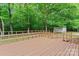 Home exterior showcasing a spacious wooden deck with railing and lush green trees in the background at 1773 Baldwin Ln, Lincolnton, NC 28092