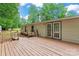 Back of house showcasing a wooden deck, white siding, and lush green trees in the background at 1773 Baldwin Ln, Lincolnton, NC 28092