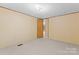 Neutral bedroom featuring wall paneling, carpet flooring, and access to a closet and attached bath at 1773 Baldwin Ln, Lincolnton, NC 28092