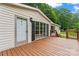 Front exterior of house with deck, white siding, dark shutters, and lush green trees in the background at 1773 Baldwin Ln, Lincolnton, NC 28092