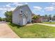 A blue house featuring a spacious backyard with a well-kept lawn and a patio area, perfect for entertaining at 1825 Stroud Park Ct, Charlotte, NC 28206