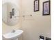 Powder room featuring a pedestal sink, round mirror, and neutral walls at 1825 Stroud Park Ct, Charlotte, NC 28206