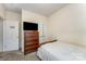 A cozy bedroom featuring a wooden dresser with TV and a comfortable bed with a white comforter at 1825 Stroud Park Ct, Charlotte, NC 28206