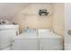 The laundry room has a side by side washer and dryer, plus a shelf for organizing laundry supplies at 1825 Stroud Park Ct, Charlotte, NC 28206