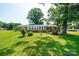 A view of the brick home framed by green lawn and manicured landscaping at 2309 13Th Street Ne Dr, Hickory, NC 28601