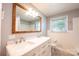 Updated bathroom with double sinks, modern fixtures, large framed mirror and tiled floor at 2309 13Th Street Ne Dr, Hickory, NC 28601