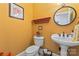 Half bathroom featuring pedestal sink, decorative mirror, and warm color palette at 2541 Penngate Dr, Sherrills Ford, NC 28673
