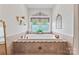 Close-up of bathtub encased in neutral tile and decorative accents at 2541 Penngate Dr, Sherrills Ford, NC 28673