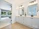 Elegant bathroom with double sinks, sleek mirrors, modern lighting, and access to the bedroom at 314 Southern Cross Ln, Matthews, NC 28105