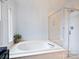 Bright bathroom with a soaking tub, a glass-enclosed shower, and natural light at 314 Southern Cross Ln, Matthews, NC 28105